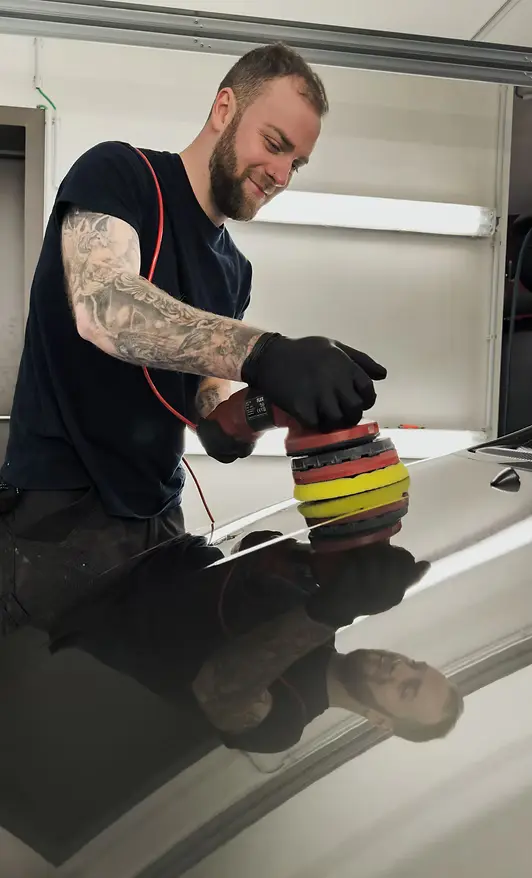 Detailer die een keramische coating aanbrengt op een Tesla Model 3 met een professionele applicator